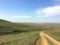 Unpaved dry dirt country road in spring steppe, offroad drive