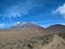Unpaved path leading to Mount Kilimanjaro under blue sky with light clouds, Tanzania