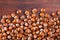 Unpeeled hazelnut on wooden surface closeup