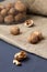 Unpeeled and peeled walnuts in shells on a black table and in a glass jar