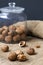 Unpeeled and peeled walnuts in shells on a black table and in a glass jar