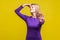 Unpleasant smell. Portrait of young woman in purple dress pinching her nose, showing stop gesture. studio shot isolated on yellow