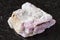 Unpolished pink Tourmaline in feldspar on black