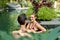 Unposed shot of smiling couple standing together in lush resort pool of luxurious hotel in tropical Bali during holiday