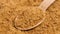 Unprocessed unrefined brown raw sugar in bamboo teaspoon.