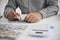 Unrecognisable businessman, accountant, banker counting money at the workplace, white background.