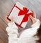 Unrecognisable child holding gift box in hands on wooden background
