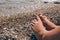 Unrecognisable child sitting on the beach near water, children& x27;s legs against sea shore as summer vacation