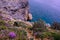 Unrecognisable mountain biker descends on a challenging trail steep towards the sea, Finale Ligure, Italy