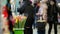 Unrecognisable people walk along an underground passage past small street shops with souvenirs and gifts. Bucket with fresh tulips