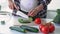 Unrecognisable pregnant woman chopping fresh vegetables in modern light kitchen