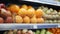 Unrecognizable African American man standing in supermarket and choosing oranges