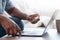 Unrecognizable african man disinfecting laptop keyboard surface with antiseptic disinfectant spray