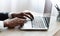 Unrecognizable african man typing at laptop in modern office