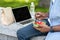 Unrecognizable Afro Man Eating Vegetable Salad And Using Laptop Outdoors