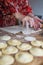 Unrecognizable aged woman cutting puff pastry with a glass to prepare dumplings