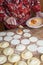 Unrecognizable aged woman filling dumplings with tuna, boiled egg and tomato sauce