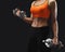 Unrecognizable athletic woman with dumbbells