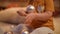 Unrecognizable baby girl playing with New Year ball sitting on carpet at home indoors. Caucasian little toddler child