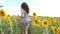 Unrecognizable beautiful girl running on yellow sunflower field. Happy young woman jogging through the meadow during