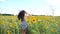 Unrecognizable beautiful girl running through yellow sunflower field. Young woman in dress showing joyful emotions