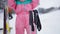 Unrecognizable blurred female skier taking ski helmet and poles. Young Caucasian woman in ski suit resting at winter