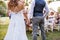 Unrecognizable bride and groom with guests at wedding reception outside in the backyard.