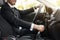 Unrecognizable businessman holding hand on gear, driving car