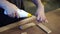 Unrecognizable carpenter applies glue to wooden parts. Handwork concept