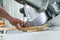 Unrecognizable caucasian carpenter holding wooden plank next to working circular saw. Electric equipment used in