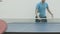 Unrecognizable Caucasian sportswoman competing in ping-pong with blurred sportsman. Two sportive adult Caucasian people
