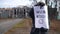 Unrecognizable Caucasian woman protesting with No housing needed banner outdoors. Slim protestor on autumn spring day