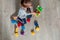Unrecognizable Child girl having fun and build of bright plastic construction blocks. Toddler playing on the floor. Developing toy