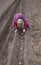 unrecognizable child leans over to plant sprouted potatoes in rows in the ground in spring