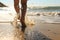 Unrecognizable child running on the beach, closeup of legs