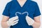 Unrecognizable doctor holding two heart-shaped clear dental aligners