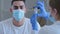 Unrecognizable doctor woman nurse in medical mask and latex gloves holds shows bottle with covid-19 vaccine coronavirus