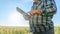 Unrecognizable farmer browsing tablet in countryside