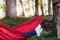 Unrecognizable feet of woman relaxing in orange hammock. Camping outdoors. autumn season at sunset