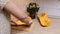 Unrecognizable female cooking fresh prolate butternut squash, remove seeds from half on wooden board in the kitchen.