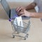 Unrecognizable female doctor working at a desk on a laptop. Mini shopping trolley full of pills. Online pharmacy concept