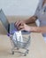 Unrecognizable female doctor working at a desk on a laptop. Mini shopping trolley full of pills. Online pharmacy concept