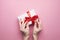 Unrecognizable Female Hands Packed Gift For Valentines Day On Pink Background, Top View