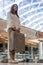 Unrecognizable female passenger holding suitcase posing at duty free international airport terminal