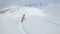 Unrecognizable female snowboarder rides off piste on a perfect winter day.