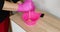 Unrecognizable female woman in pink glove squeezing pigment in bowl