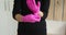 Unrecognizable female woman putting on latex pink gloves