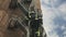 Unrecognizable fireman climbing ladder outside brick building