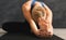 Unrecognizable fitness woman stretching at grey background indoors