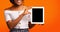 Unrecognizable Girl Showing Tablet Screen Standing On Orange Background, Mockup